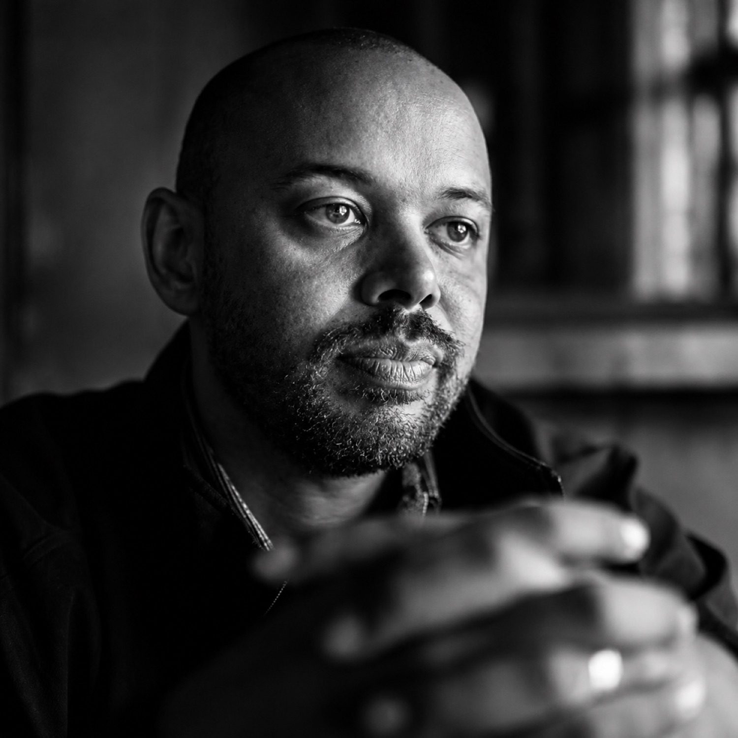 Black and white portrait of Khary, chin resting on his hands